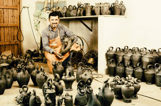 istock Potter sitting with ceramics vessels 953521584