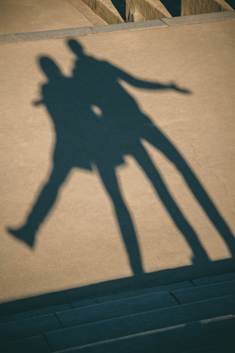 The shadow of the couple on the floor. Silhouette of the shadows on the asphalt.