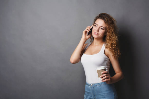 istock Young girl talking on phone with coffee 953529038