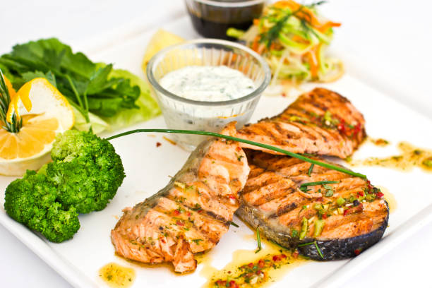 стейки из лосося, на гриле. подается с овощами и специями на белой тарелке - main course salmon meal course стоковые фото и изображения