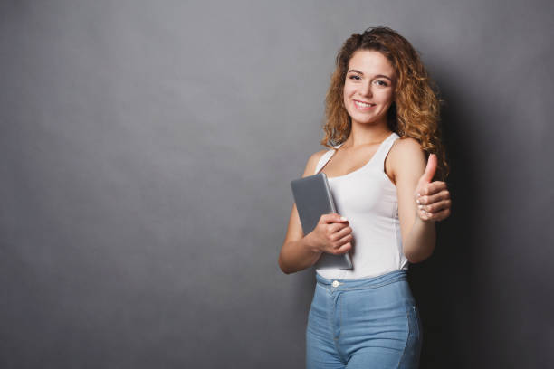 istock Woman with thumb up gesture on gray background 953529088