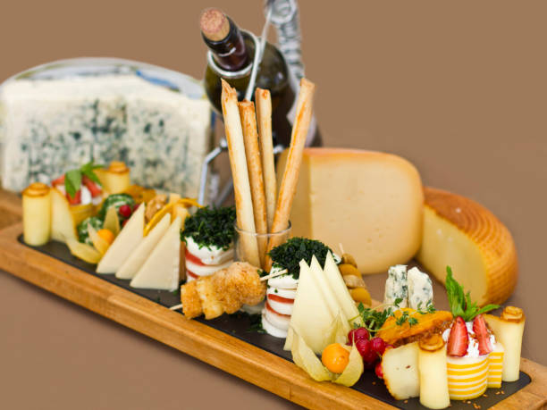 istock Cheese plate: roquefort with blue mold, cheddar, smoked cheese, mozzarella on a wooden board. Decorated with bread sticks 953529914