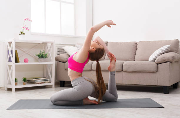 istock Woman training yoga in king pigeon pose. 953533500