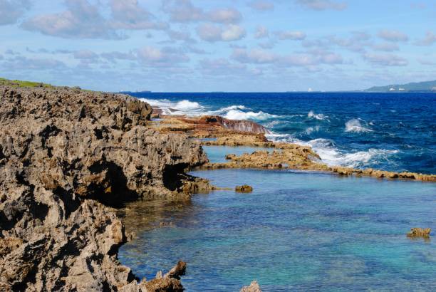 costas rocosas afiladas con claras aguas azules del canal tinian - saipan fotografías e imágenes de stock