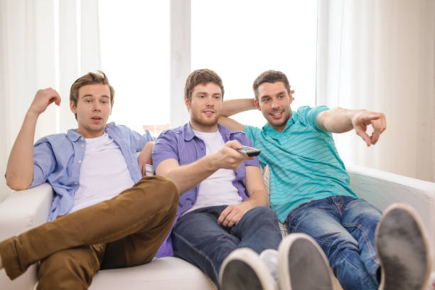 istock smiling friends with remote control at home 953533918