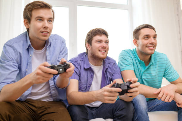 istock smiling friends playing video games at home 953534614