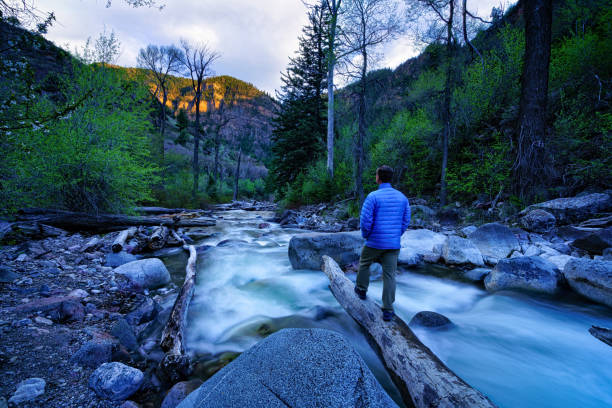 istock Man Standing on Log Over Whitewater Creek 953537882