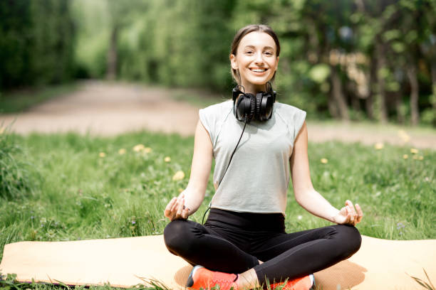 istock Young woman doing yoga in the park 953552700
