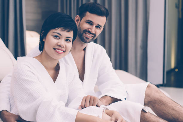 istock Happy couple embracing on deckchair in spa 953553300