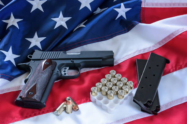 istock The second amendment and gun control in the US, concept. A handgun, magazines, bullets, and the american constitution on the USA flag. 953558424