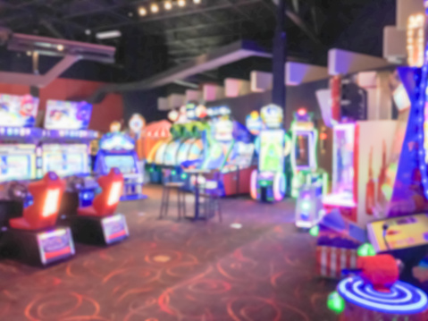 Blurred image game room at entertainment complex in America, abstract arcade area.