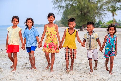 Group of Cambodian children walking together on the beach, Cambodia