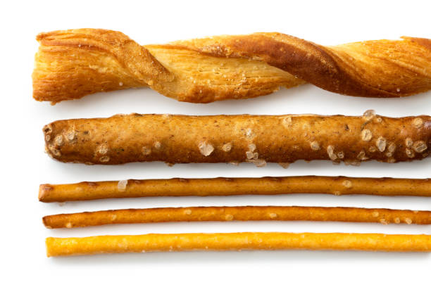 Selection of grissini, pretzels and cheese sticks on white from above.