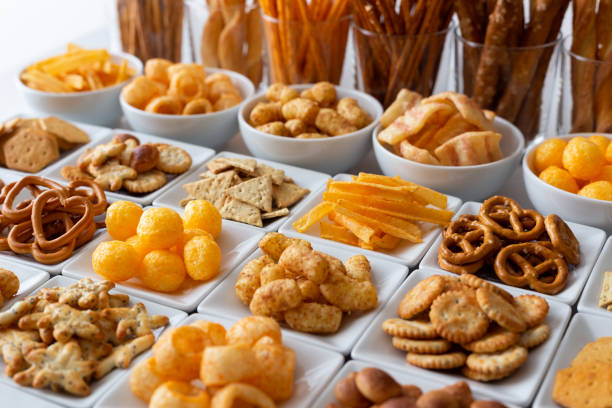 linhas de muitos tipos de snacks salgados em pratos de cerâmicos brancos. - comida salgada - fotografias e filmes do acervo