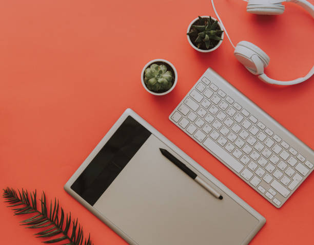 istock Flat Lay office desk work space with graphic tablet, keyboard, headphones on pastel. Creative Designer concept. 953592540