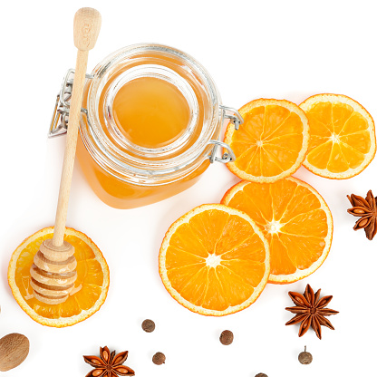 Bee honey and orange slices isolated on white background. Flat lay, top view.