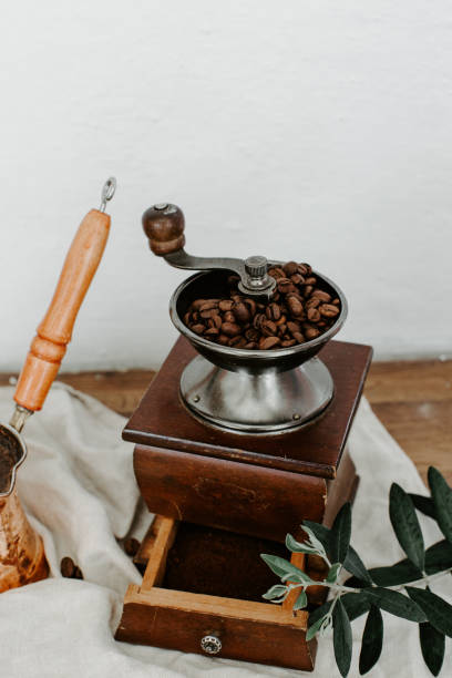 istock Rustic coffee grinder with coffee on wooden table with linen napkin 953593546