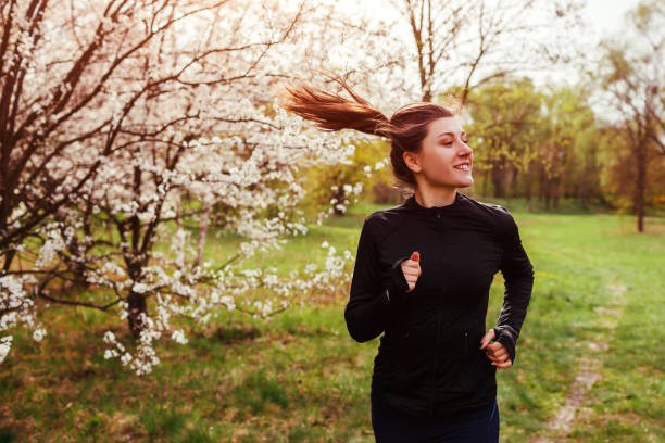 mulher feliz correndo na floresta de primavera. helathy lifestyle - helathy - fotografias e filmes do acervo