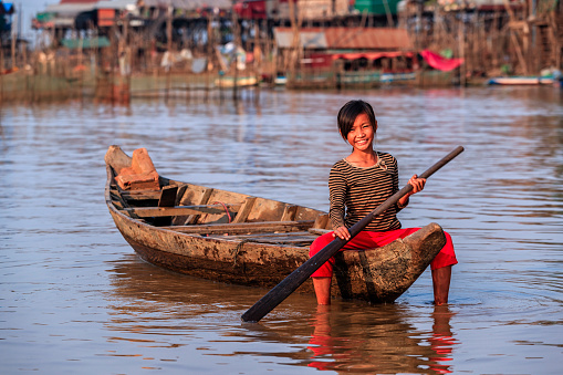 Cambodian little girl rowing a boat on Tonle Sap, Cambodia