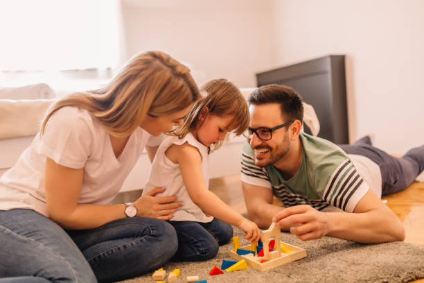 istock Happy family is having fun while they are solving puzzles on the floor in bedroom 953601068