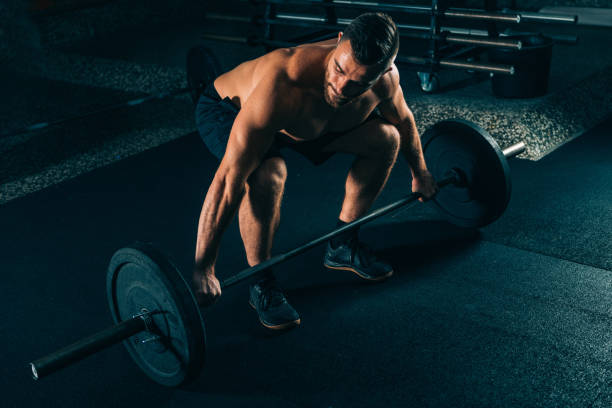 istock Cross training. Male athlete lifting weights 953605056