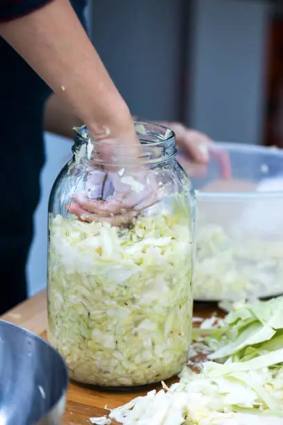 Woman making home fermented sauerkraut.