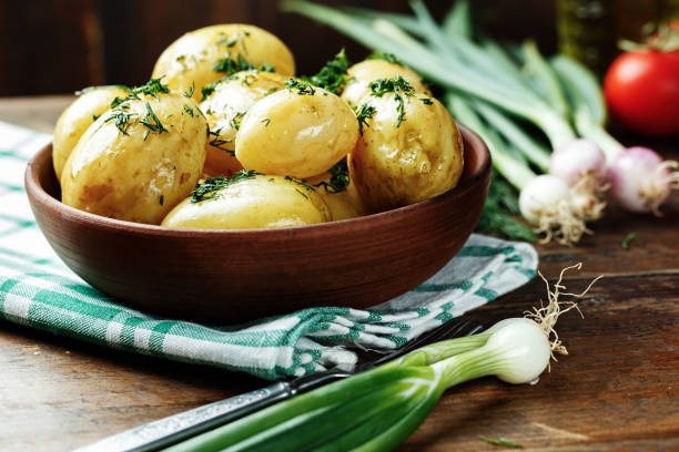 istock Boiled young potatoes with dill in a clay plate 953615280