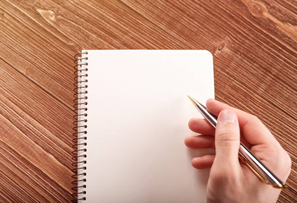 istock Human hand with pen prepare to writing on notebook. 953619618