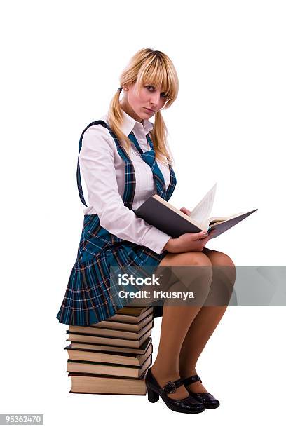 Scolara È Seduto Sulla Pila Di Libri E Lettura - Fotografie stock e altre immagini di Abbigliamento - Abbigliamento, Abbigliamento elegante, Adolescente