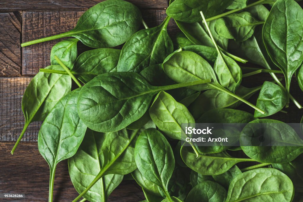 Baby spinach leaf as a background Baby spinach leaf on wood as a background. Horizontal composition. Detox, healthy lifestyle, healthy eating, vegan diet concept Spinach Stock Photo