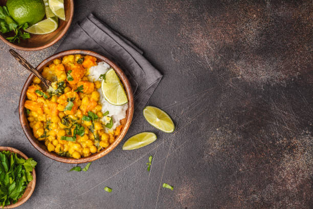 Vegan Sweet Potato Chickpea curry in wooden bowl on a dark background, top view. Healthy vegetarian food concept.