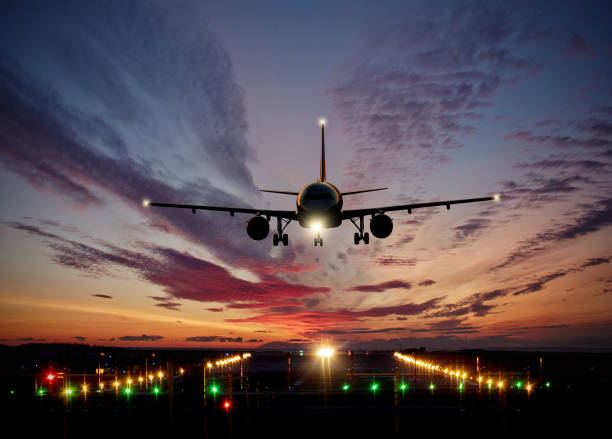 istock Passengers commercial airplane landing on runway with dramatic sunset sky 953638552