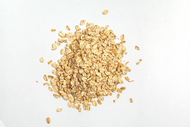 grani grezzi di farina d'avena isolati su sfondo bianco, vista dall'alto. - oat wheat oatmeal cereal plant foto e immagini stock