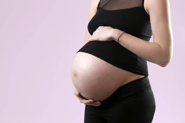 istock Pregnant woman holding her belly - studio shot 953642356
