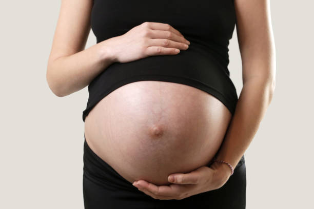 istock Pregnant woman holding her belly - studio shot 953642732