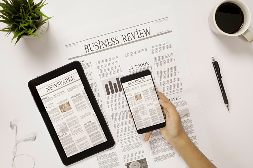 newspaper over office desk with tablets