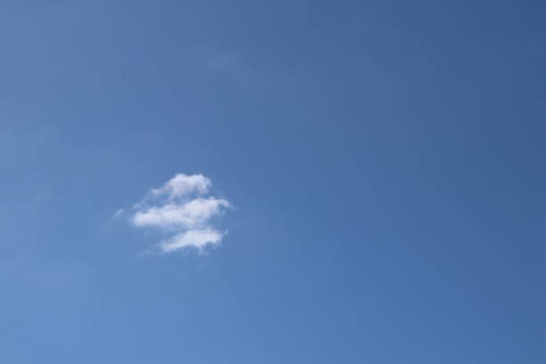 istock Close up of fluffy, wispy white cloud against blue sky 953650924