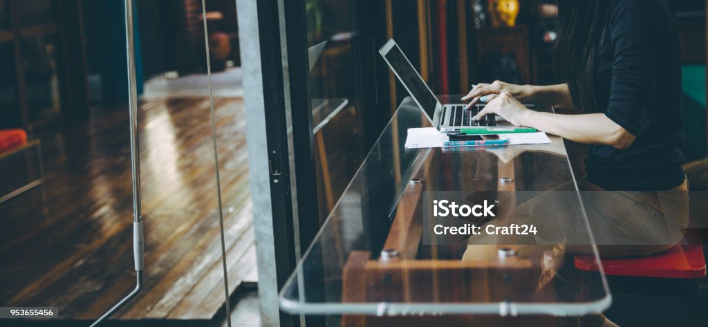 Beautiful young Asian girl working at a coffee shop with a laptop. Beautiful young Asian girl working at a coffee shop with a laptop.female freelancer connecting to internet via computer. Casual Thinking Browsing Concept Homework Stock Photo