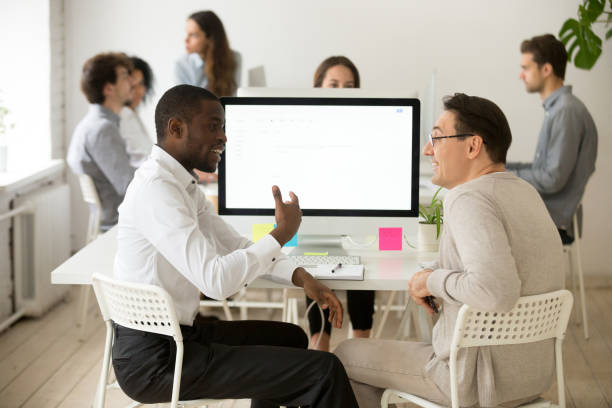 istock Friendly smiling diverse male colleagues having pleasant conversation at work 953656010
