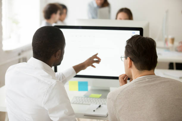 istock African team leader explaining colleague corporate application usage, rear view 953656042