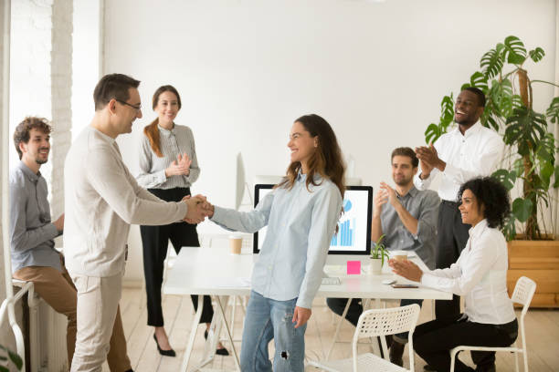 istock Boss promoting employee, hiring intern congratulating with handshake, team applauding 953656048