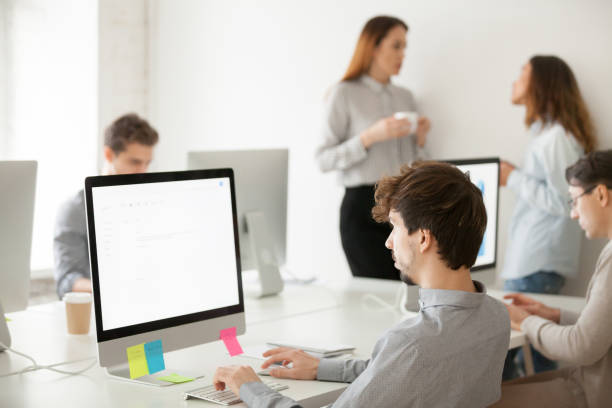 istock Young male employee working on computer writing email in office 953656076