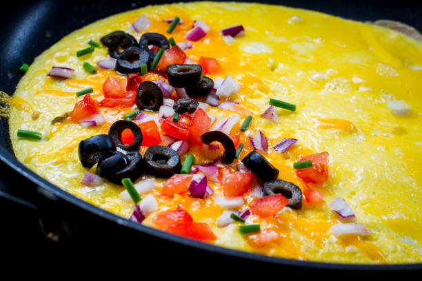 Making the Perfect Low Carb Omelette Eggs, cheese, spinach, onion, olives, tomato and seasoningson a bamboo cutting board,, the ingredients for a perfect ketogenic diet healthy breakfast. goodfood stock pictures, royalty-free photos & images