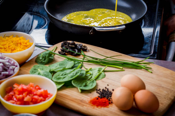 Making the Perfect Low Carb Omelette Eggs, cheese, spinach, onion, olives, tomato and seasoningson a bamboo cutting board,, the ingredients for a perfect ketogenic diet healthy breakfast. goodfood stock pictures, royalty-free photos & images