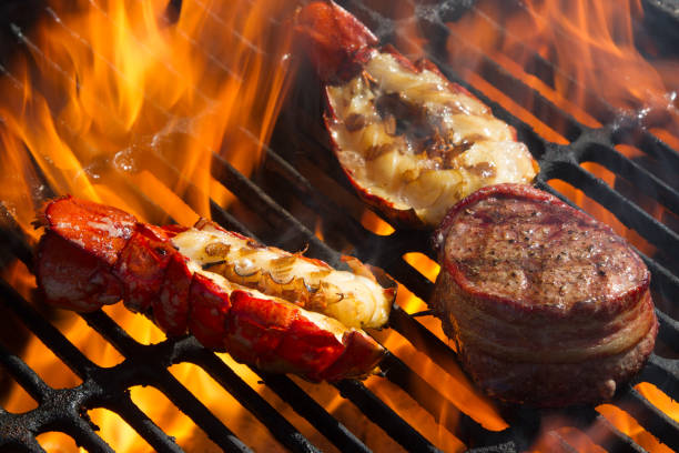Flaming Grilled Low Carb Lobster Tail Flaming Low Carb Ketogenic Diet Lobster Tail and Bacon Filet goodfood stock pictures, royalty-free photos & images
