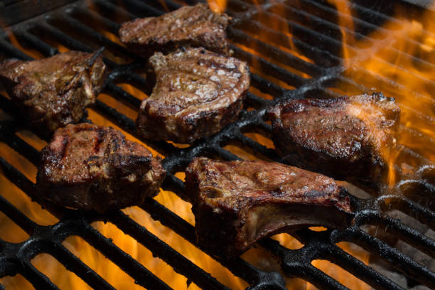 Low Carb, High Fat Lamb or Pork Chops on a Flaming Grill Delicious Grilled Lamb or Pork Chops, part of a ketogenic or low carb diet flaming on a grill goodfood stock pictures, royalty-free photos & images