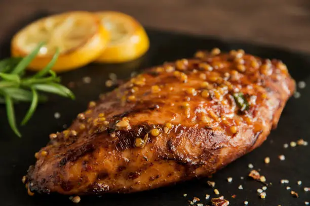 Photo of roasted chicken fillet breast with lemon tomato rosemary mustard seeds honey