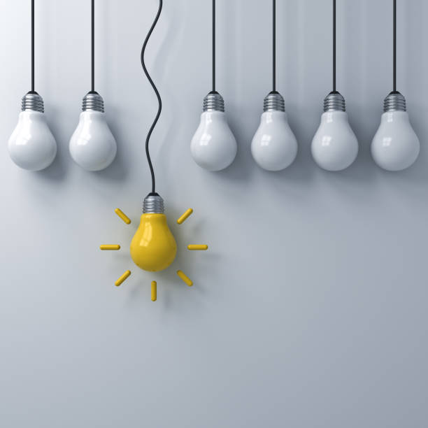istock Think different concept , One hanging yellow idea bulb standing out from the dim unlit light bulbs on white wall background , leadership and individuality creative idea concepts . 3D rendering 953668748
