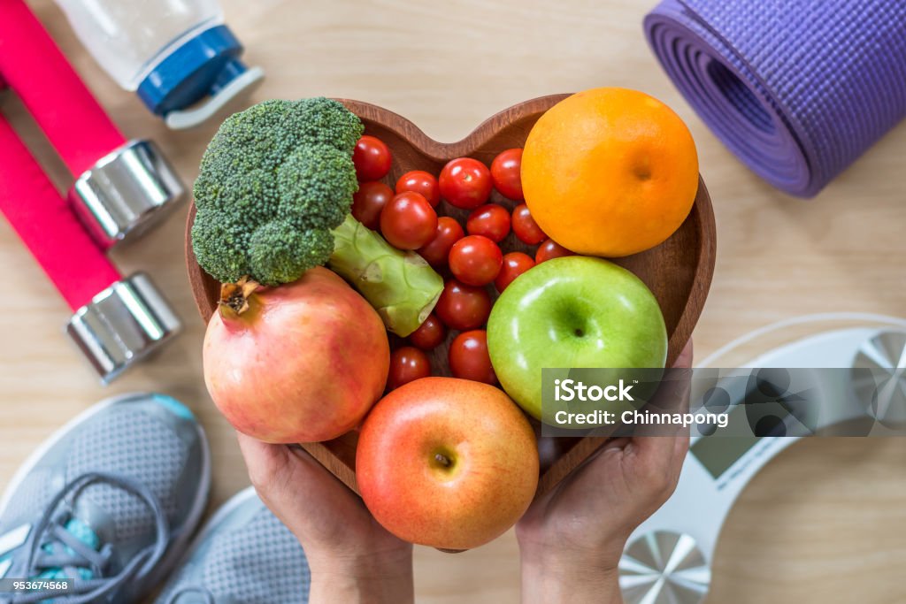Healthy lifestyle concept, clean food good health dietary in heart dish with sporty gym aerobic body exercise workout training class equipment, weight scale and sports shoes in fitness center Healthy Lifestyle Stock Photo