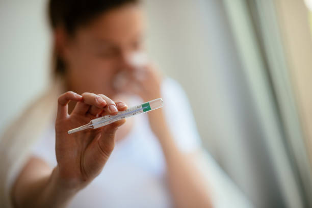 istock Close up of woman holding thermometer 953678286